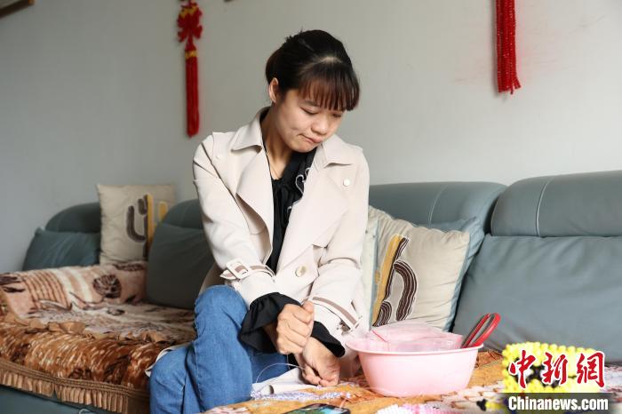 图为李红燕在制作串珠工艺品。 李晨 摄 图为李红燕在制作串珠工艺品。 李晨 摄