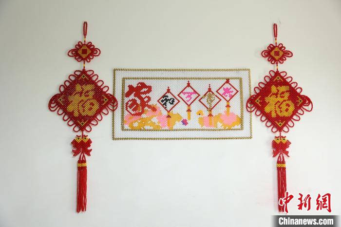 图为李红燕制作的中国结与十字绣串珠作品。 李晨 摄 图为李红燕制作的中国结与十字绣串珠作品。 李晨 摄
