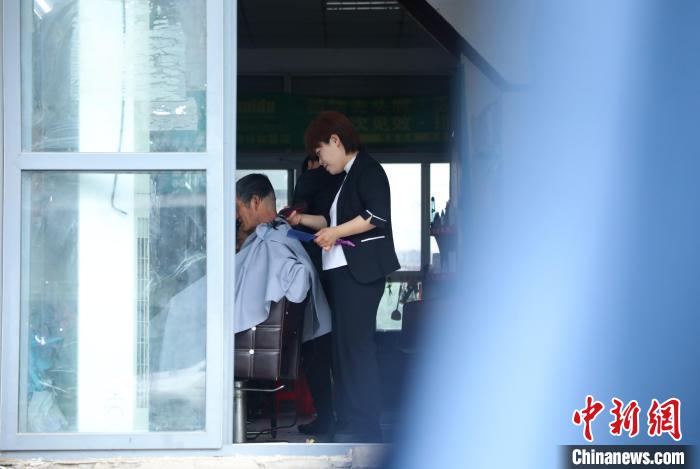 周丽丽正在给客人理发。 陈家乐 摄 周丽丽正在给客人理发。 陈家乐 摄