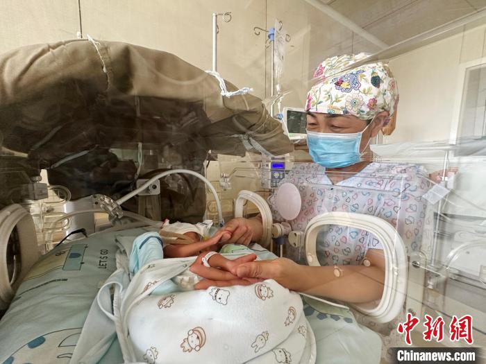 在新生儿科,马凤丽要时刻关注保温箱里早产儿的状况。 郭佳 摄 在新生儿科,马凤丽要时刻关注保温箱里早产儿的状况。 郭佳 摄