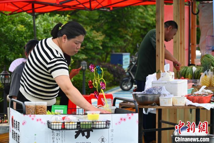 上金贝村村民摆摊售卖畲族美食。 余汕康 摄 上金贝村村民摆摊售卖畲族美食。 余汕康 摄