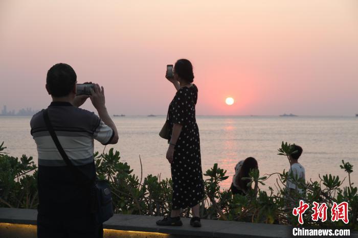 “立夏”时节,海口市民游客傍晚出游欣赏落日,拍照留念。 张月和 摄 “立夏”时节,海口市民游客傍晚出游欣赏落日,拍照留念。 张月和 摄