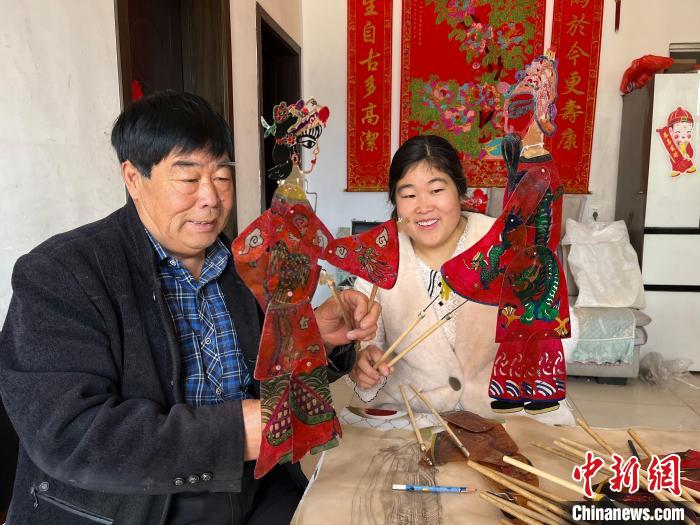 图为冯克献和女儿展示制作完成的皮影道具。 马瑾 摄 图为冯克献和女儿展示制作完成的皮影道具。 马瑾 摄