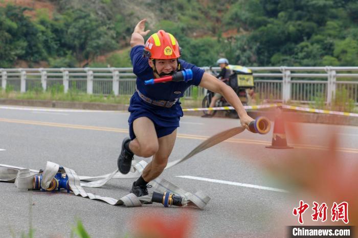 在福建省南平市延平区,消防员在尖兵挑战赛100米消防障碍项目中连接水带。 郑振盛 摄 在福建省南平市延平区,消防员在尖兵挑战赛100米消防障碍项目中连接水带。 郑振盛 摄