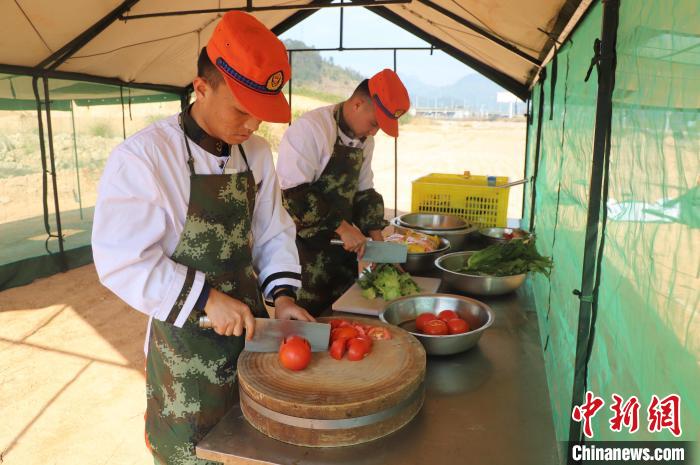 李恒端(右)在为驻训人员做饭。　吴皓 摄