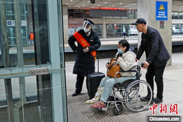 铁路上海南站工作人员帮助轮椅旅客快速出站。 殷立勤 摄 铁路上海南站工作人员帮助轮椅旅客快速出站。 殷立勤 摄