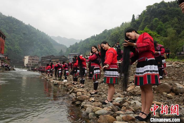 4月22日,在广西龙胜各族自治县龙脊镇黄洛瑶寨,当地瑶族民众在河边开展长发梳妆表演。 韦吉阳 摄 4月22日,在广西龙胜各族自治县龙脊镇黄洛瑶寨,当地瑶族民众在河边开展长发梳妆表演。 韦吉阳 摄