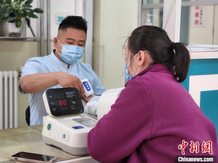 李超在急诊科为患者量血压。 赵晓 摄 李超在急诊科为患者量血压。 赵晓 摄