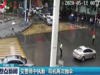 贵州：交警雨中执勤 司机两次抛伞