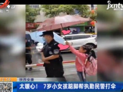 陕西安康：太暖心！  7岁小女孩踮脚帮执勤民警打伞