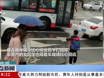 四川：男孩街头遇到女同学 雨中隔空比心