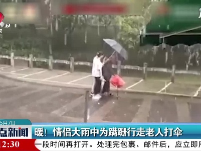 广西：暖！情侣大雨中为蹒跚行走老人打伞