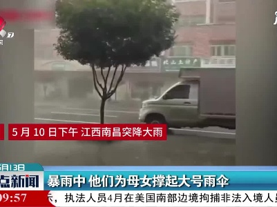 南昌：暴雨中 他们为母女撑起大号雨伞