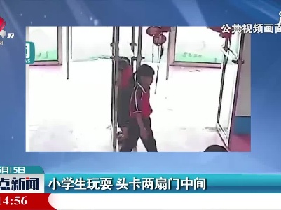 山东：小学生玩耍 头卡两扇门中间