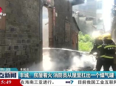 丰城：房屋着火 消防员从屋里扛出一个煤气罐