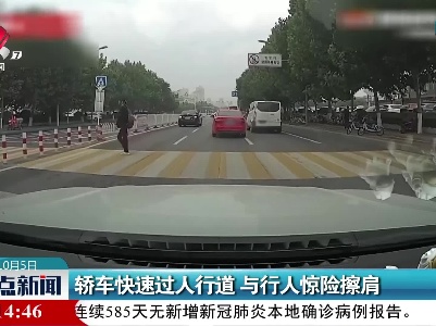 轿车快速过人行道 与行人惊险擦肩