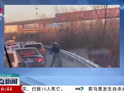 小伙蹬自行车为被堵救护车开道