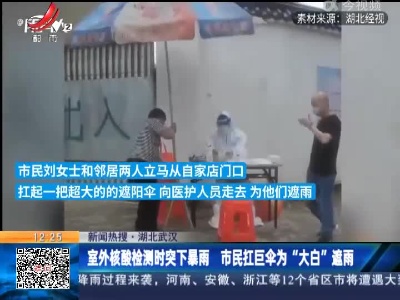 【新闻热搜】湖北武汉：室外核酸检测时突下暴雨 市民扛巨伞为“大白”遮雨