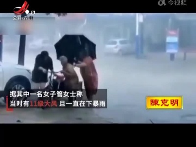 两女子暴雨中帮老人推车