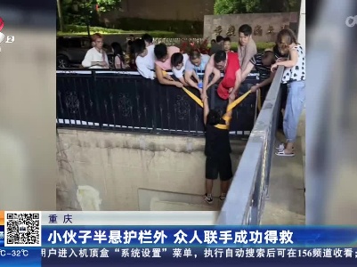 重庆：小伙子半悬护栏外 众人联手成功得救