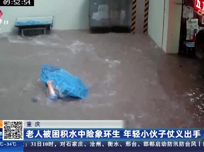 重庆：老人被困积水中险象环生 年轻小伙子仗义出手