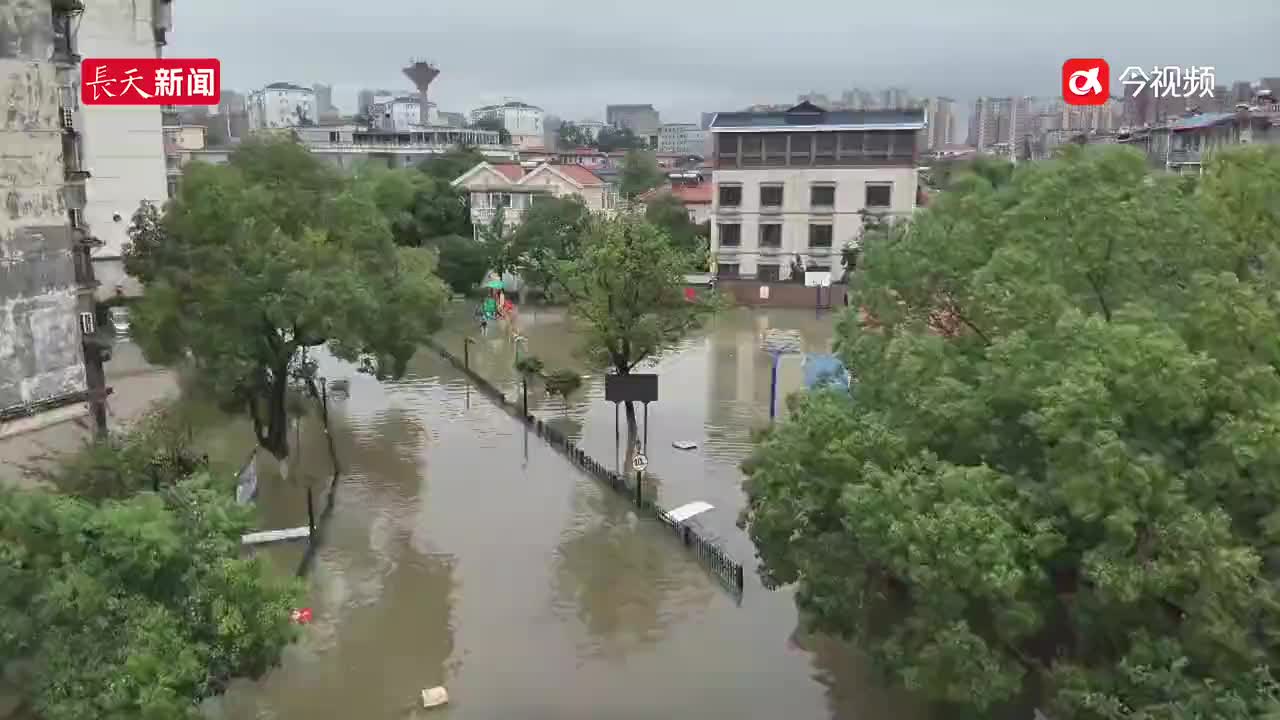 九江一小区因暴雨致道路被淹，救援人员开展排水作业并转移群众