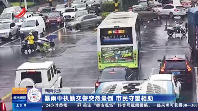 湖南长沙：暴雨中执勤交警突然晕倒 市民守望相助