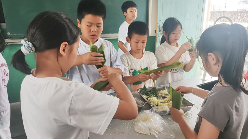 瑞金市瑞明小学开展美食坊社团活动——包粽子