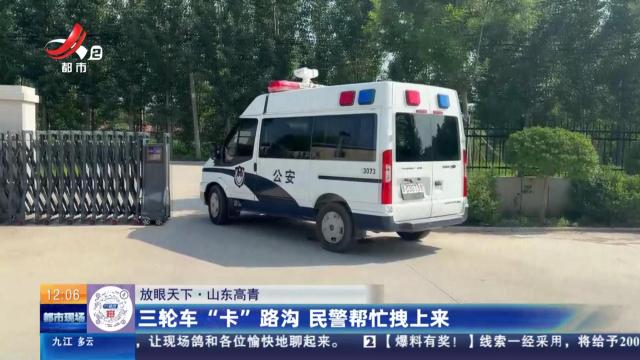 【放眼天下】山东高青：三轮车“卡”路沟 民警帮忙拽上来