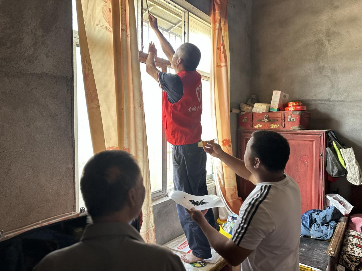 风雨无情人有情——南城县新丰街镇杨桥村党员志愿者为残障脱贫户补窗护家