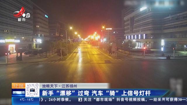 【放眼天下】江苏扬州：新手“漂移”过弯 汽车“骑”上信号灯杆