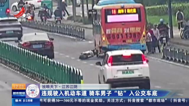 【放眼天下】江苏江阴：违规驶入机动车道 骑车男子“钻”入公交车底